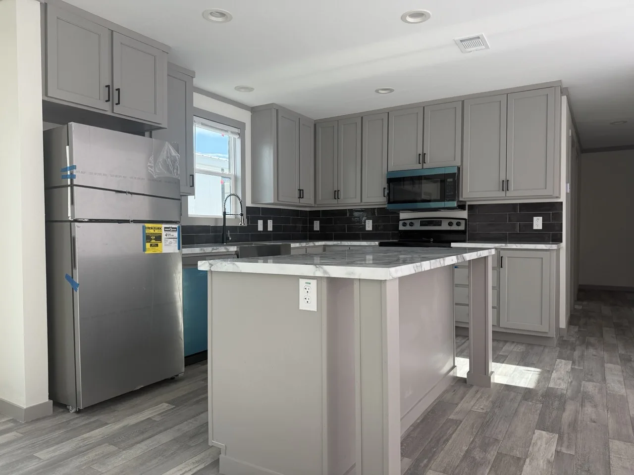 Modern kitchen in The Coleman doublewide home featuring abundant cabinet storage