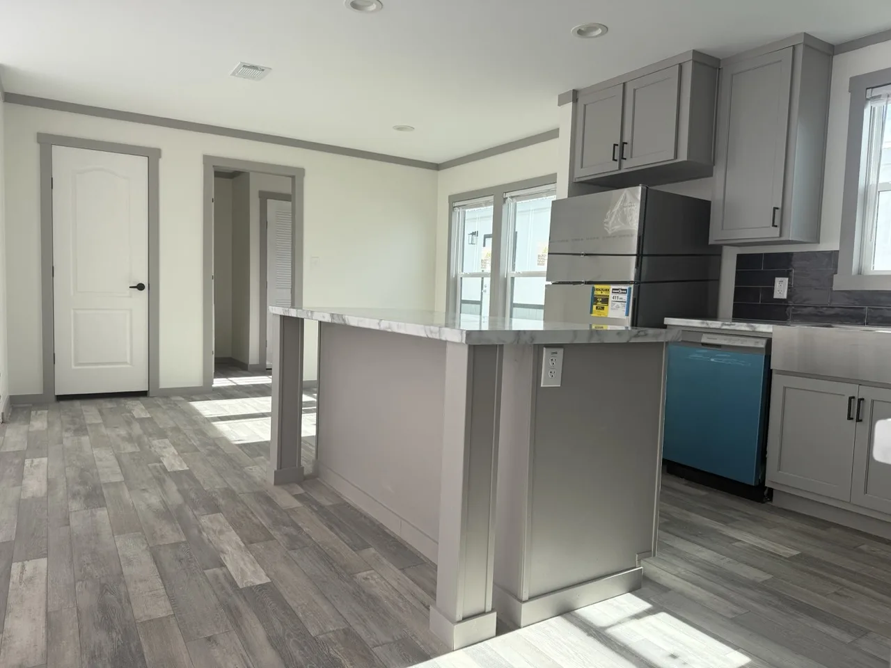 Kitchen inside The Coleman doublewide manufactured home in Texas with large island and open layout